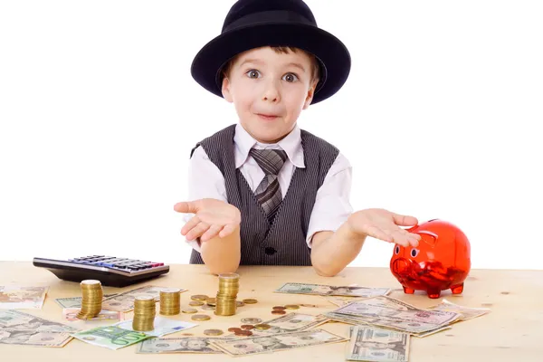 Sluwe jongen aan de tafel met geld — Stockfoto