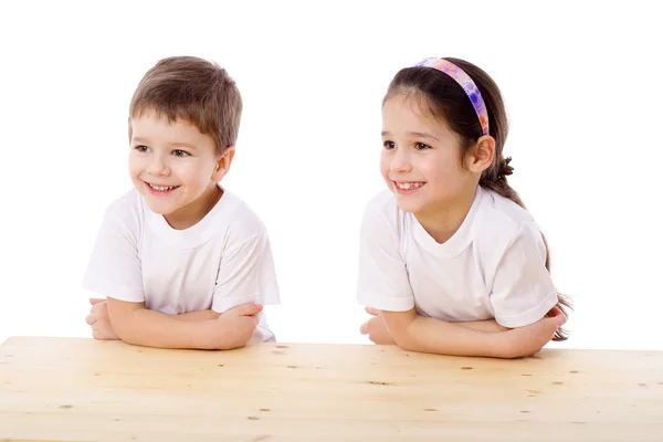 Dwoje dzieci uśmiechający się na biurku — Zdjęcie stockowe