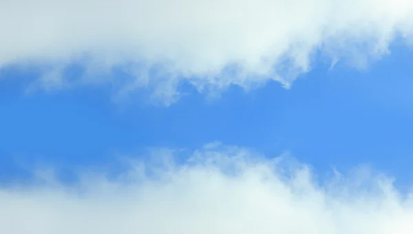 Sininen taivas peittyy valkoisiin pilviin — kuvapankkivalokuva