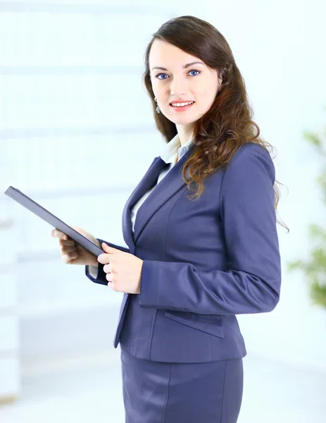 Retrato de uma jovem mulher de negócios bonito com o plano de trabalho sorrindo, em um ambiente de escritório . — Fotografia de Stock