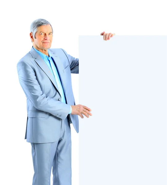 Nice businessman at the age holds white poster. Isolated on a white background. — Stock Photo, Image