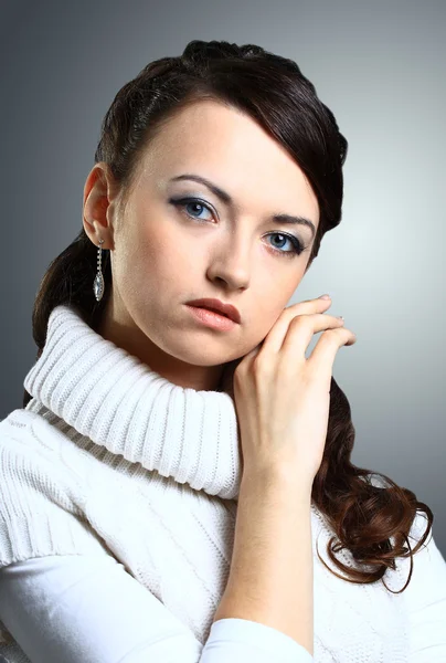 Hermosa chica pensativa en suéter. Aislado sobre un fondo gris . — Foto de Stock