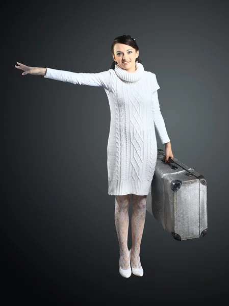 Une belle fille avec une valise à la main. Isolé sur un fond gris . — Photo