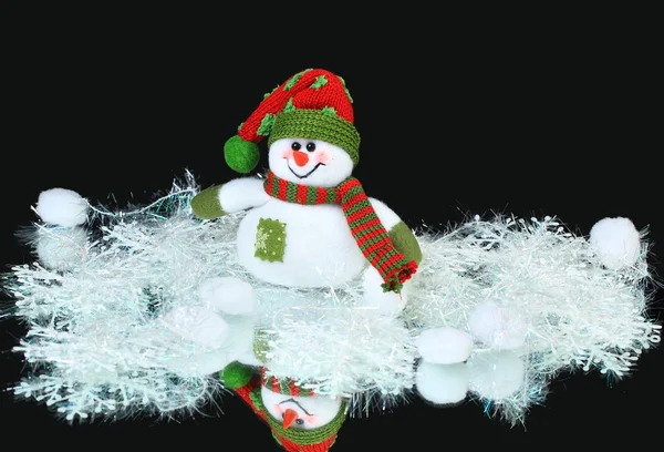 Speelgoed versierd met een sneeuwpop, op een zwarte achtergrond — Stockfoto