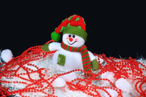 Brinquedo decorado com um boneco de neve, sobre um fundo preto — Fotografia de Stock