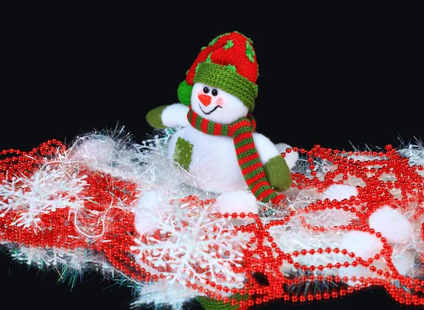 Brinquedo decorado com um boneco de neve, sobre um fundo preto — Fotografia de Stock