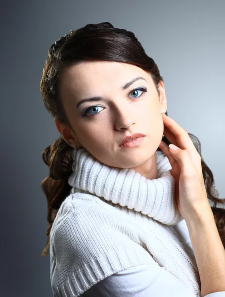 Hermosa chica pensativa en suéter. Aislado sobre un fondo gris . —  Fotos de Stock