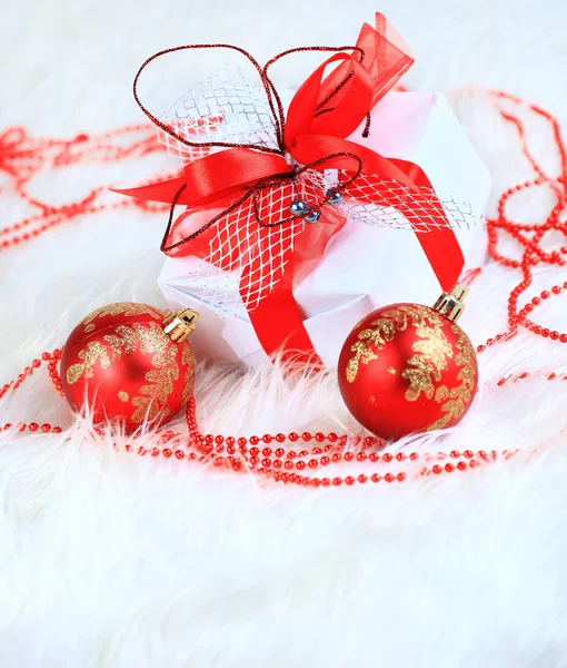 Presente de Natal com bolas vermelhas arco — Fotografia de Stock