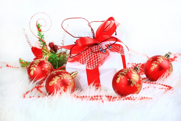 Christmas gift with red balls bow — Stock Photo, Image