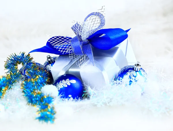 Bolas festivas com caixa de presente na neve — Fotografia de Stock