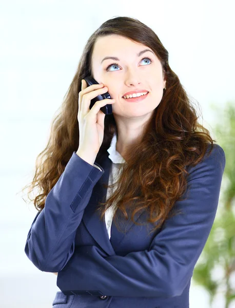 Портрет милой молодой деловой леди, разговаривающей по телефону, улыбающейся, в — стоковое фото
