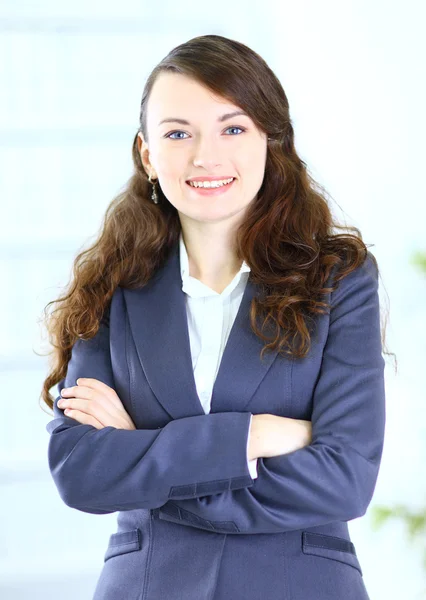 Porträtt av en söt ung affärskvinna som ler, i en kontorsmiljö — Stockfoto