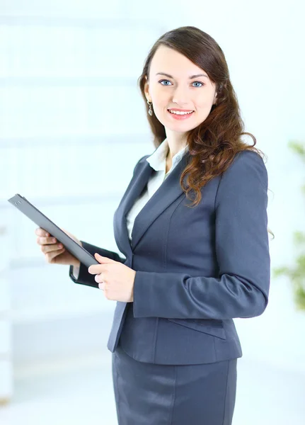 Retrato de una linda mujer de negocios joven con el plan de trabajo sonriendo, en una o — Foto de Stock