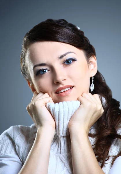 Красива дівчина посміхається в светрі. Ізольовані на сірому фоні . — стокове фото