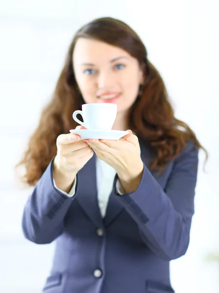 Mulher de negócios oferece uma xícara de café no escritório — Fotografia de Stock