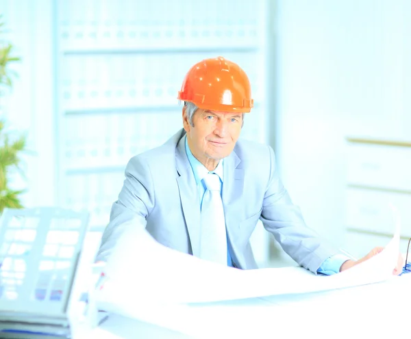 Portrait of professional architect with blueprints sitting behin — Stock Photo, Image