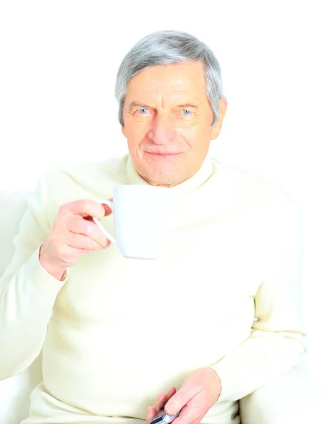 Porträtt av äldre man med kaffe mugg, ler mot kameran — Stockfoto