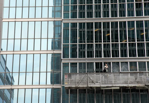 Stock image Window washer cleaning windows on a modern highrise office