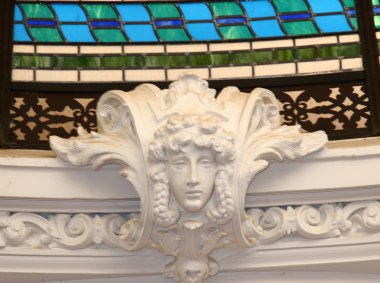 Stained glass surrounded by intricate plaster moulding on ceiling clipart