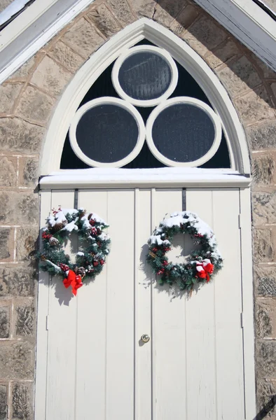 stock image Arched curch entrance doors with christmas wreaths in winter