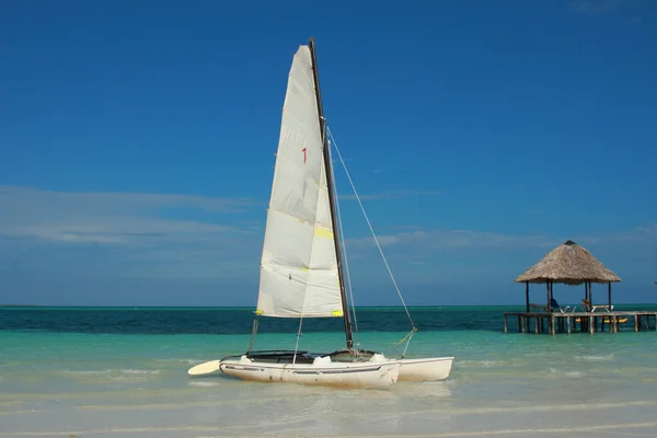 Sailboat on tropical beach — Stock Photo, Image