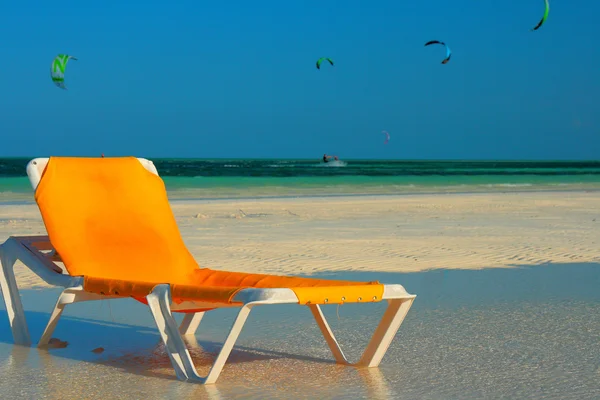 Lounge chair on beach by the ocean — Stock Photo, Image