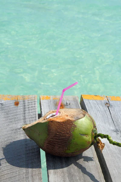Kokosnød drink med udsigt over tropisk strand - Stock-foto