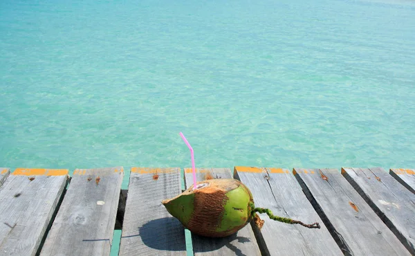 Coconut drink overlooking tropical beach — Stock Photo, Image