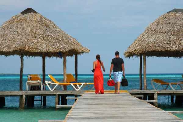 Couple in romantic walk along tropical ocean pier — Stock Photo, Image