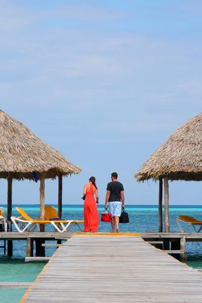 Couple in romantic walk along tropical ocean pier — Stock Photo, Image