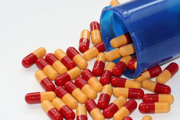 Prescription drugs spilling out of an open container — Stock Photo, Image