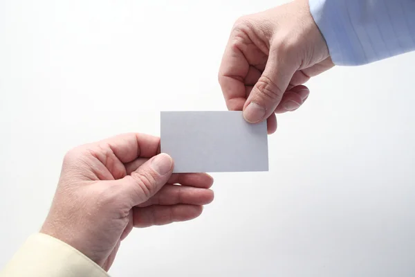 stock image One business man handing a card to another businessman