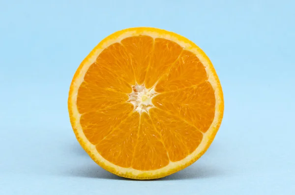 Mezza frutta arancione su sfondo azzurro — Foto Stock