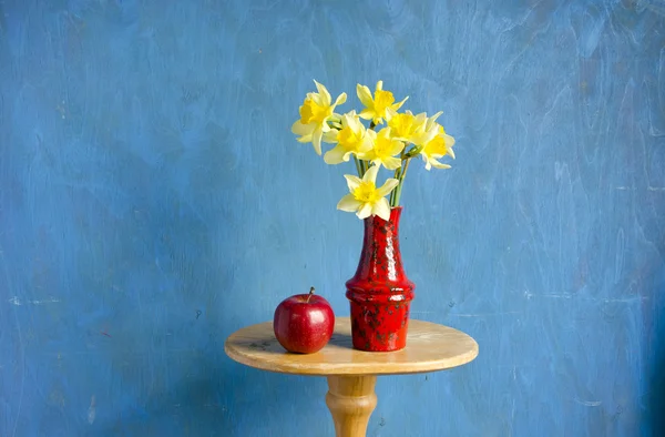 Vase with narcissus and red apple — Stock Photo, Image