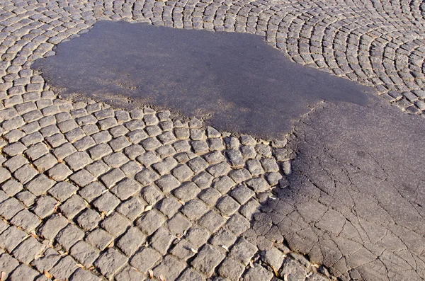 Pouliční asfalt a zázemí kamenné cihly — Stock fotografie