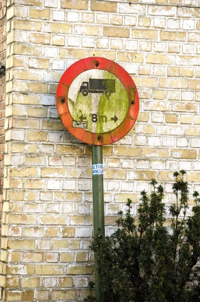 Grunge road sign near wall — Stock Photo, Image