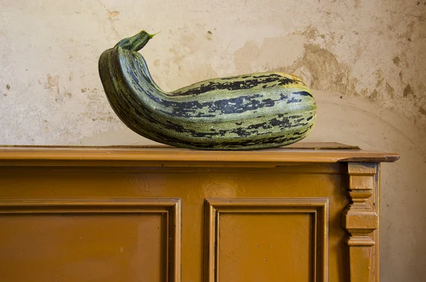 Green courgette on vintage cupboard — Stock Photo, Image