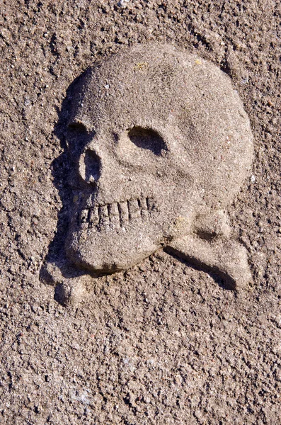 stock image Primitive skull and crosbones relief