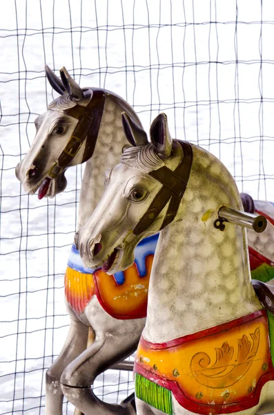 stock image Two carousel horses in winter time