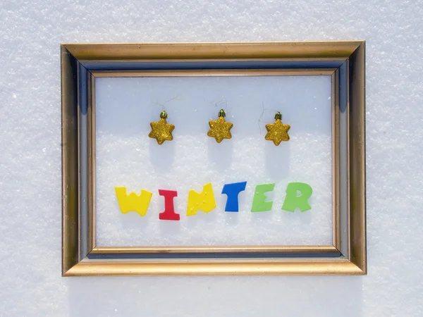 Wort Winter im Rahmen auf Schnee — Stockfoto