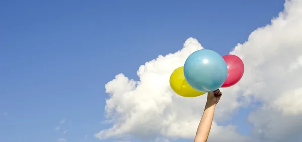 Dziewczyny ręki trzymającej trzy kolorowe balony — Zdjęcie stockowe