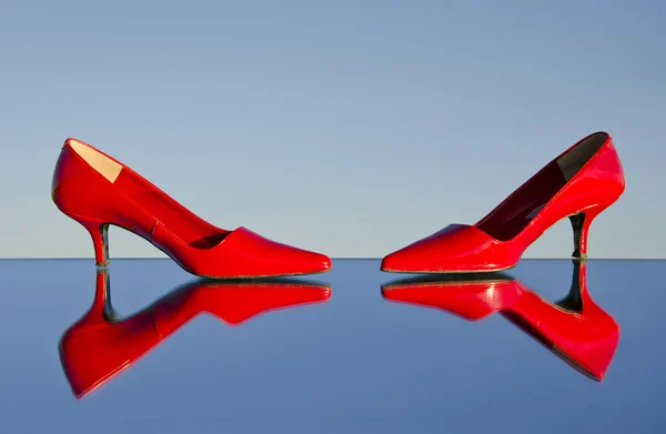 stock image Two red stiletto on mirror