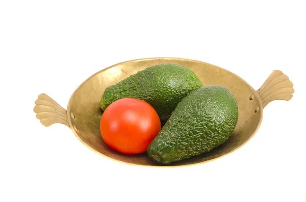 Изолированная медная тарелка с авокадо и помидорами — стоковое фото