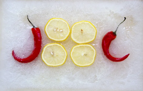 Zitronenscheiben und Paprika in Eis — Stockfoto