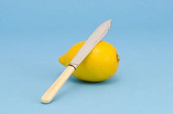 Een gele citroen met mes — Stockfoto