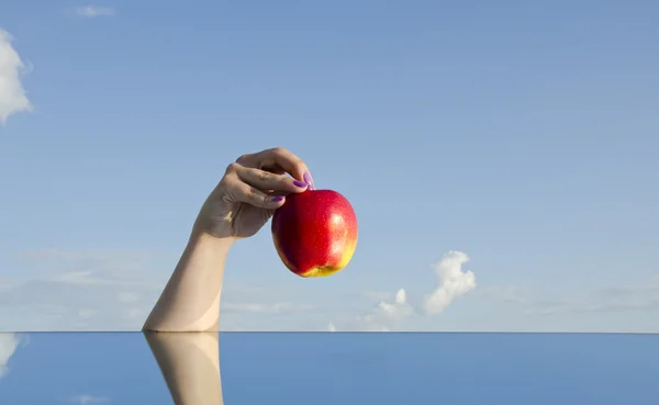 Κορίτσι χέρι που κρατά κόκκινο μήλο και ουρανό — Φωτογραφία Αρχείου
