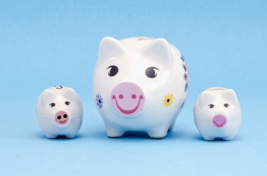 drie piggybanks op azuurblauwe achtergrond