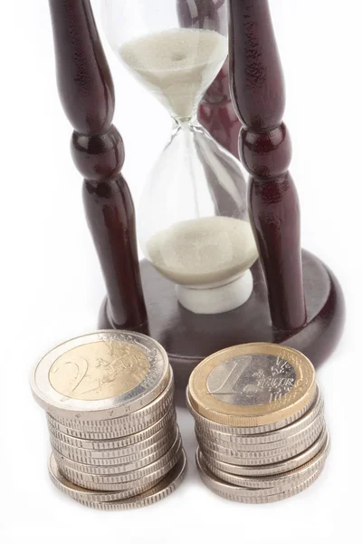 Пісочний годинник і євро монети — стокове фото