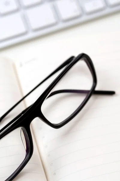 Brýle a klávesnice — Stock fotografie