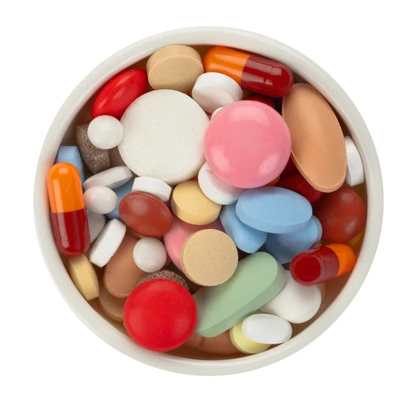 Pílulas coloridas em tigela branca - vista superior — Fotografia de Stock